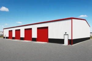 Commercial 40x100 metal building with a row of sidewall roll-up doors and a gravel truck yard at midday