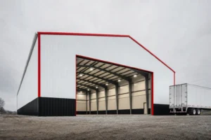 Wide 60x100 clear-span metal building with an open equipment door and a semi trailer for scale