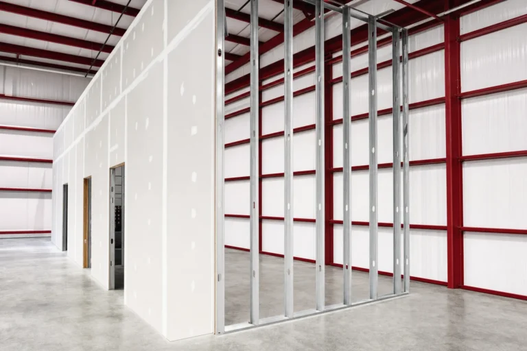 Framed and drywalled interior partition under construction inside a metal building