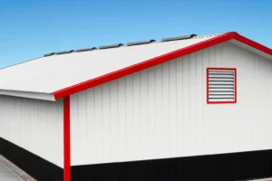 Metal building roof line with ridge vents at the peak and a louver on the gable wall